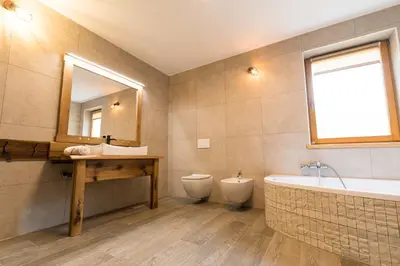a bathroom with a tub and a toilet and a sink at LARCH HOUSE in Cerklje na Gorenjskem