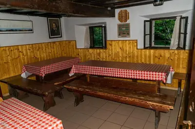 a room with two benches and a table and windows at Home Puščava in Kranj