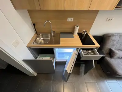 a kitchen with a sink and a couch in a room at Studio Spark Ljubljana in Ljubljana