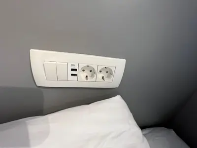 a clock on the wall above a bed at Studio Spark Ljubljana in Ljubljana