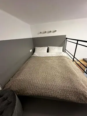 a small bedroom with a bed with white pillows at Studio Spark Ljubljana in Ljubljana