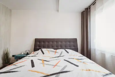 a bedroom with a bed with a black and white comforter at Cozy Nest in quiet neighbourhood, free parking in Ljubljana
