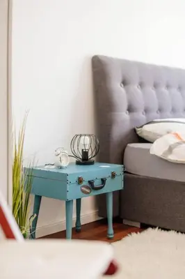 a blue table next to a bed in a room at Cozy Nest in quiet neighbourhood, free parking in Ljubljana