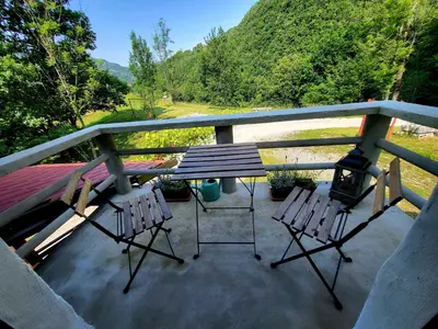 a porch with a picnic table and two chairs at Čukova bajta in Most na Soči