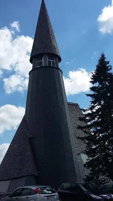 a large building with a steeple with cars parked in front at Apartma Rogla Gaber 110 in Zreče