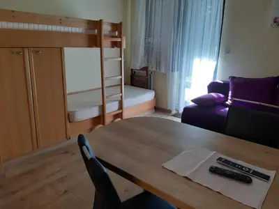 a living room with a table and a bunk bed at Apartma Rogla Gaber 110 in Zreče