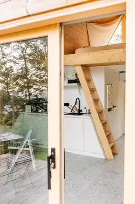 a kitchen and dining area of a house with sliding glass doors at Cozy A-Frame Retreat Near Ljubljana With Hot Tub in Cerklje na Gorenjskem