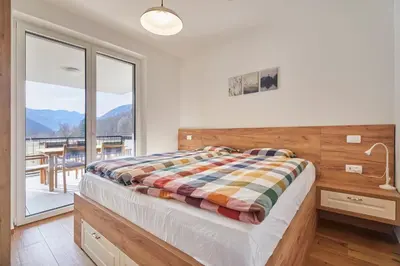a bedroom with a bed and a large window at Apartments Svitnjak in Bovec