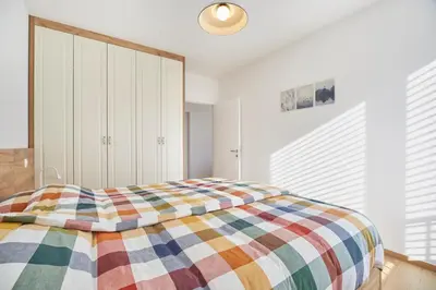 a bedroom with a bed with a colorful blanket at Apartments Svitnjak in Bovec