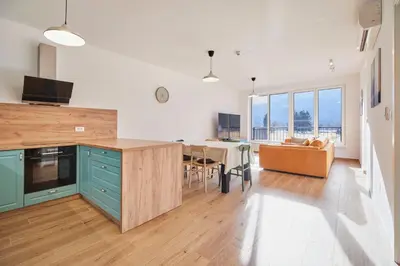 a kitchen and living room with a couch and a table at Apartments Svitnjak in Bovec