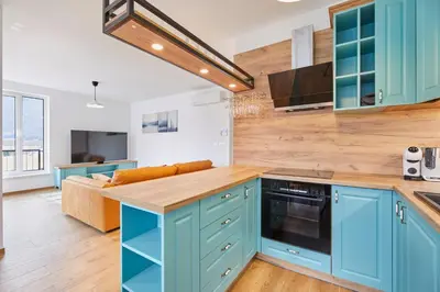 a kitchen with blue cabinets and a couch at Apartments Svitnjak in Bovec