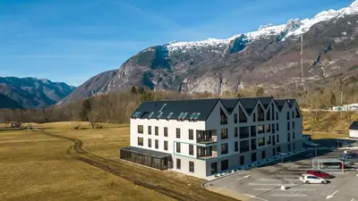 an aerial view of a building with mountains in the background at Apartments Svitnjak in Bovec