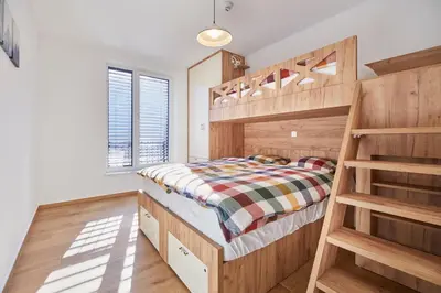 a bedroom with a wooden bunk bed and a ladder at Apartments Svitnjak in Bovec
