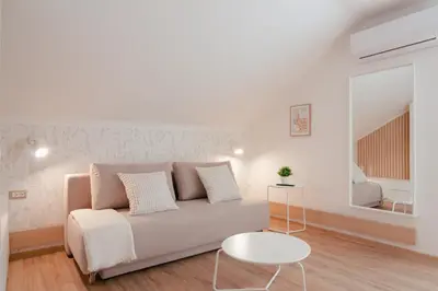 a white living room with a couch and a table at Luxury 2 bedroom NEW apartment with private parking in Ljubljana