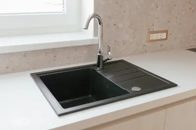 a black kitchen sink with a faucet on a counter at Luxury 2 bedroom NEW apartment with private parking in Ljubljana