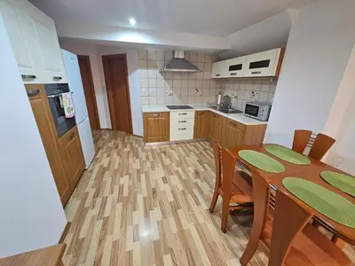 a kitchen with a wooden table and a dining room at Apartma Ferida in Bovec