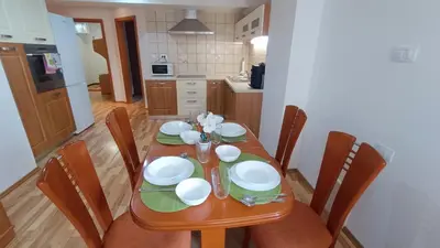 a wooden table with plates and bowls on it in a kitchen at Apartma Ferida in Bovec