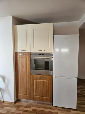 a kitchen with a white refrigerator and wooden cabinets at Apartma Ferida in Bovec