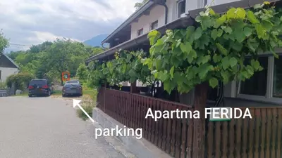 a building with a fence next to a parking lot at Apartma Ferida in Bovec