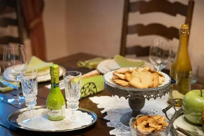 a table with a bottle of wine and a plate of food at Residence Moritz with Sauna in Mozirje