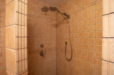a shower with a shower head in a bathroom at Residence Moritz with Sauna in Mozirje