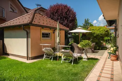a gazebo with chairs and an umbrella in a yard at Residence Moritz with Sauna in Mozirje