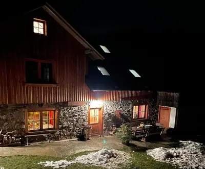 a stone building with a wooden door at night at Traditional Slovenian house in Vransko