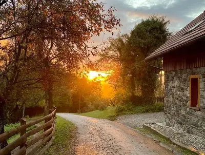 a dirt road next to a fence and a barn at Traditional Slovenian house in Vransko