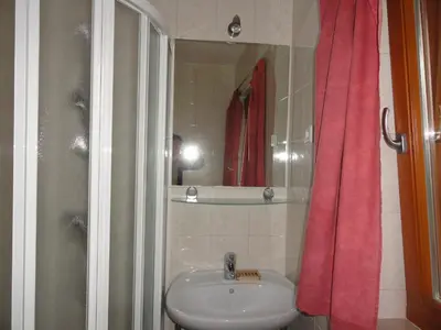 a bathroom with a sink and a red shower curtain at Farm Stay Dolinar Krainer in Bohinjska Bela