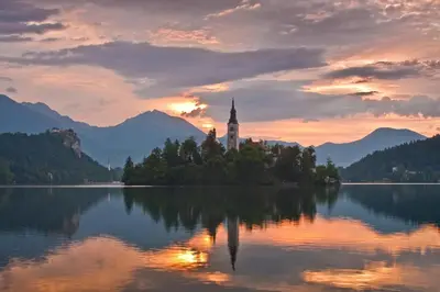 a church on an island in the middle of a lake at Farm Stay Dolinar Krainer in Bohinjska Bela