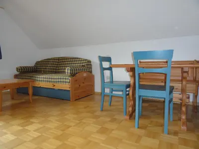 a living room with a table and chairs and a couch at Farm Stay Dolinar Krainer in Bohinjska Bela