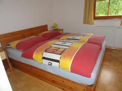 a bed with a colorful quilt on it in a bedroom at Farm Stay Dolinar Krainer in Bohinjska Bela