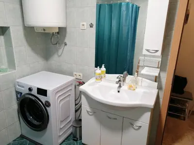 a bathroom with a washing machine and a sink at Vanessa Apartment in Ljubljana
