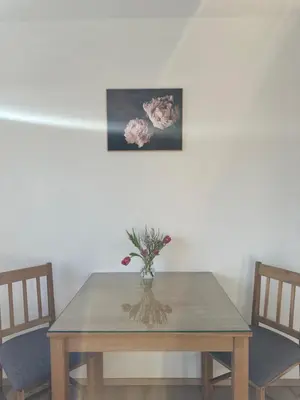 a dining room table with a vase of flowers on it at Vanessa Apartment in Ljubljana