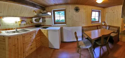 a kitchen with a table and a sink and a table and chairs at Apartments Torkar in Bled
