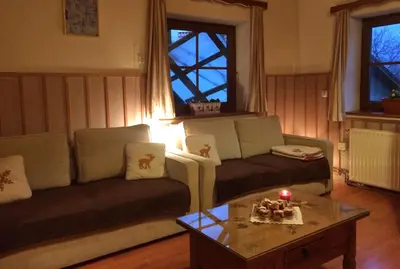 a living room with a couch and a table with a candle at Apartments Torkar in Bled