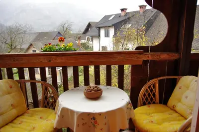 a table and chairs on a balcony with a view of a house at Apartments Torkar in Bled