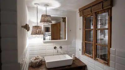 a white bathroom with a sink and a mirror at Premium Gardenguesthouse Mlinar with Pool & Sauna in Fokovci