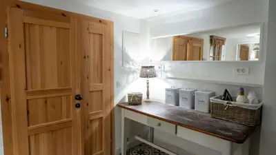 a kitchen with a wooden door and a counter with a mirror at Premium Gardenguesthouse Mlinar with Pool & Sauna in Fokovci
