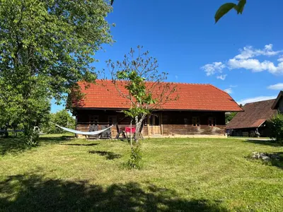 a house with a hammock in front of it at Hisa Suzana in Črnomelj