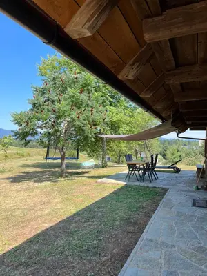 a picnic table and chairs under a wooden roof at Hisa Suzana in Črnomelj