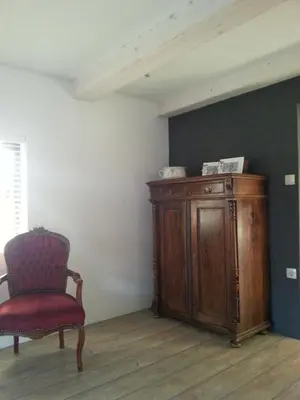 a room with a chair and a wooden cabinet at Hisa Suzana in Črnomelj