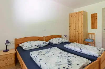 a bedroom with two twin beds with blue sheets at Apartments Bor in Bohinj