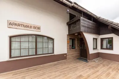a building with a balcony on the side of it at Apartments Bor in Bohinj