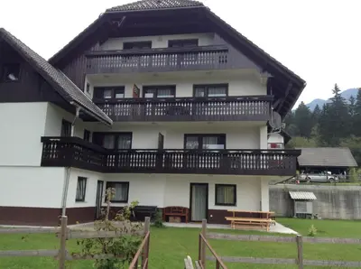 a large white house with a balcony at Apartments Bor in Bohinj