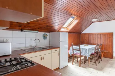 a kitchen with a sink and a table with chairs at Apartments Bor in Bohinj