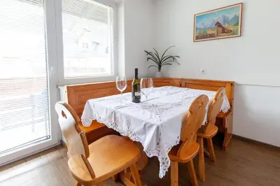 a dining room with a table with wine glasses on it at Apartments Kosir in Kranjska Gora