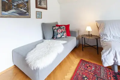 a living room with a couch with a pillow and a table at Apartments Kosir in Kranjska Gora