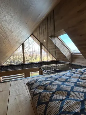 a bed in a room with a large window at Hiška pod črešnjo in Rogašovci