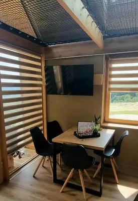 a dining room with a table with chairs and a laptop at Hiška pod črešnjo in Rogašovci